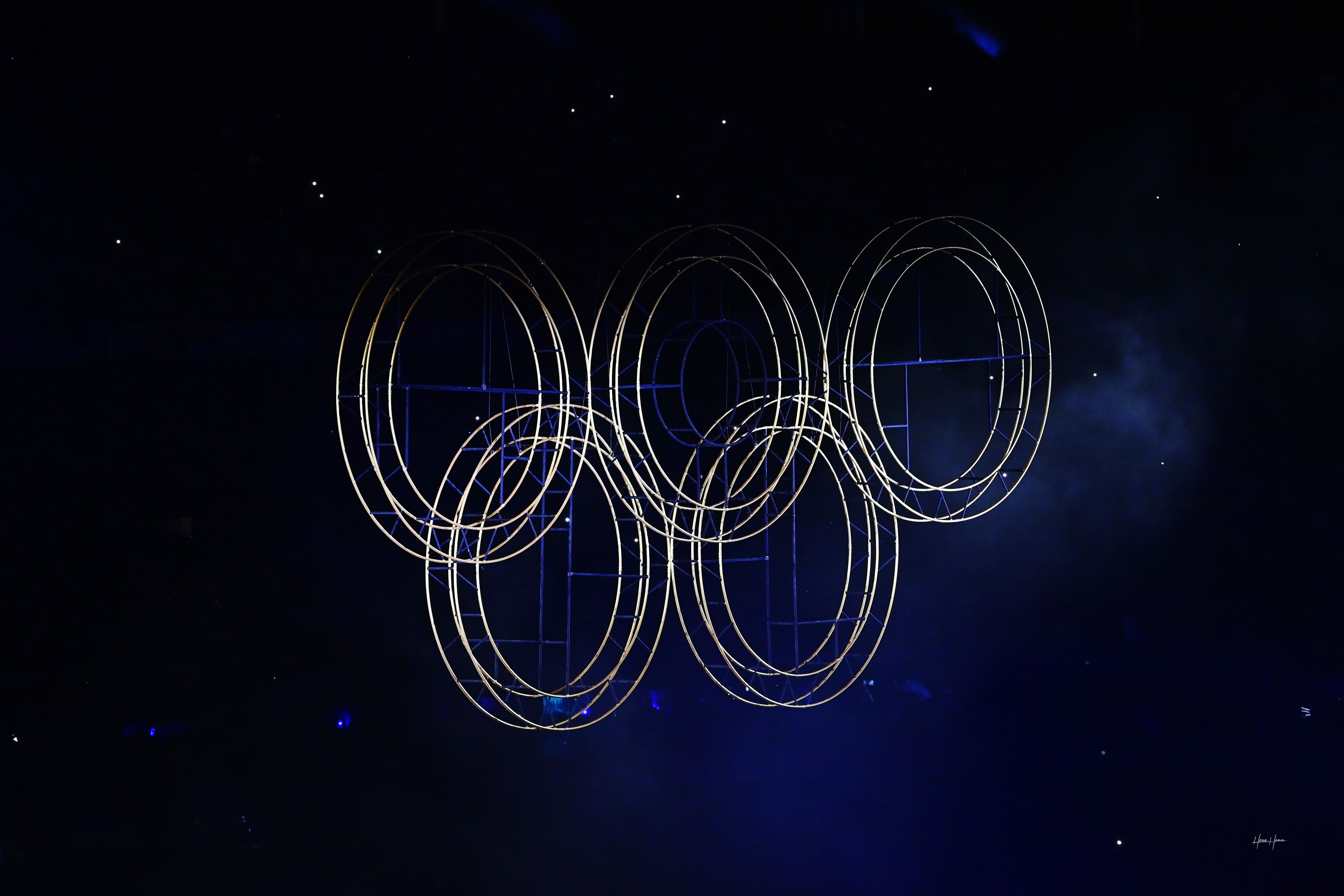 Image sombre avec anneaux olympiques lumineux