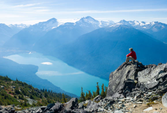 Photo d'une personne assise et admirant la montagne
