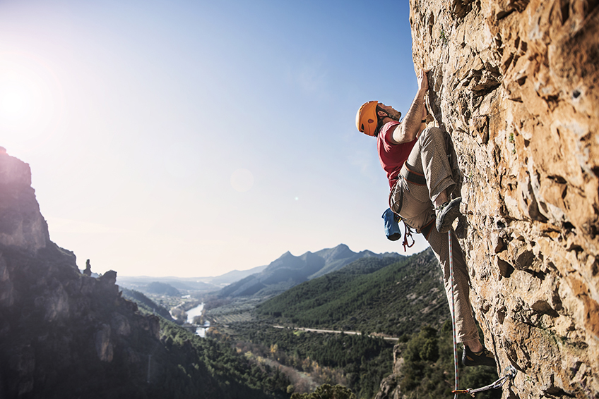 Image d'un homme escaladant une montagne raide