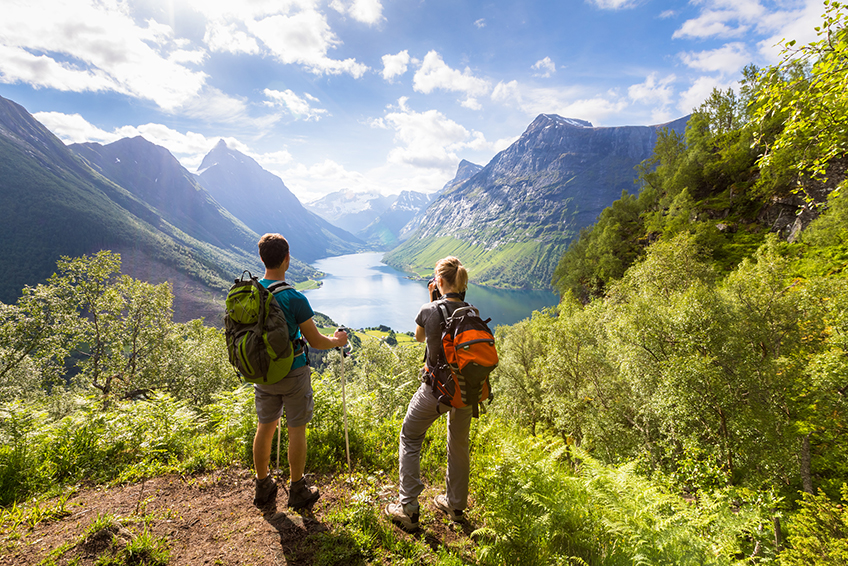 Image avec un homme et une femme en escalade contemplant la montagne en été