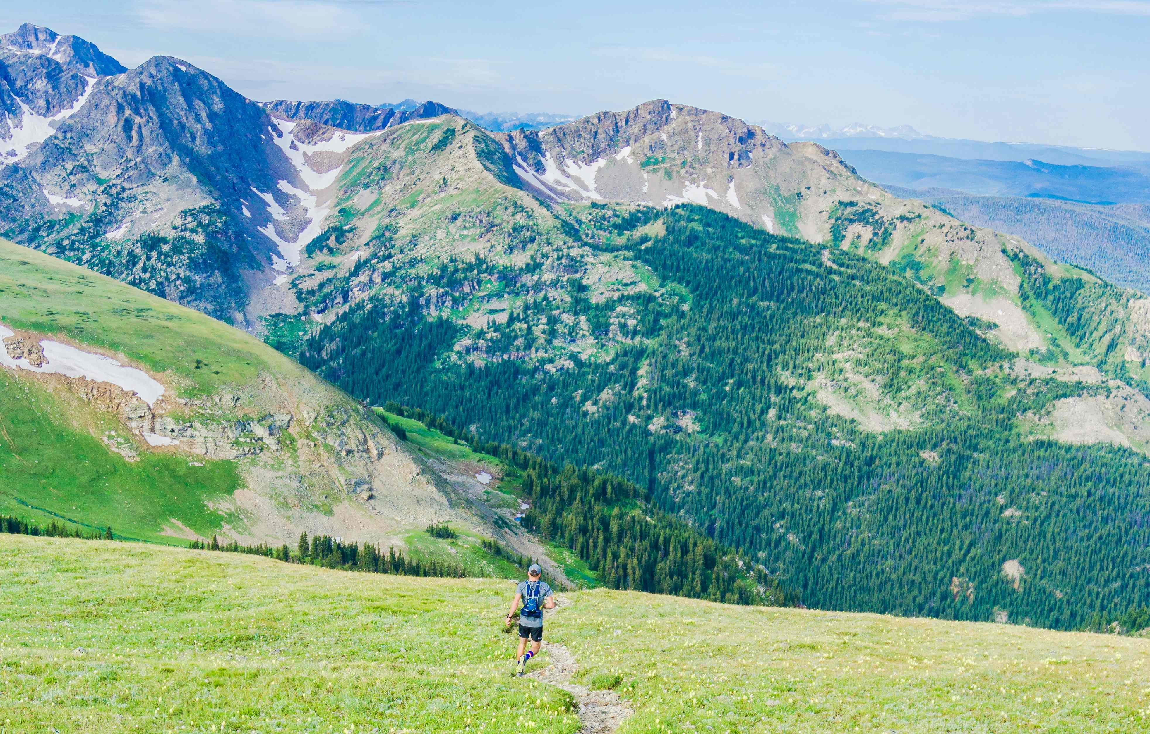 Un homme faisant de la randonnée en montagne en été