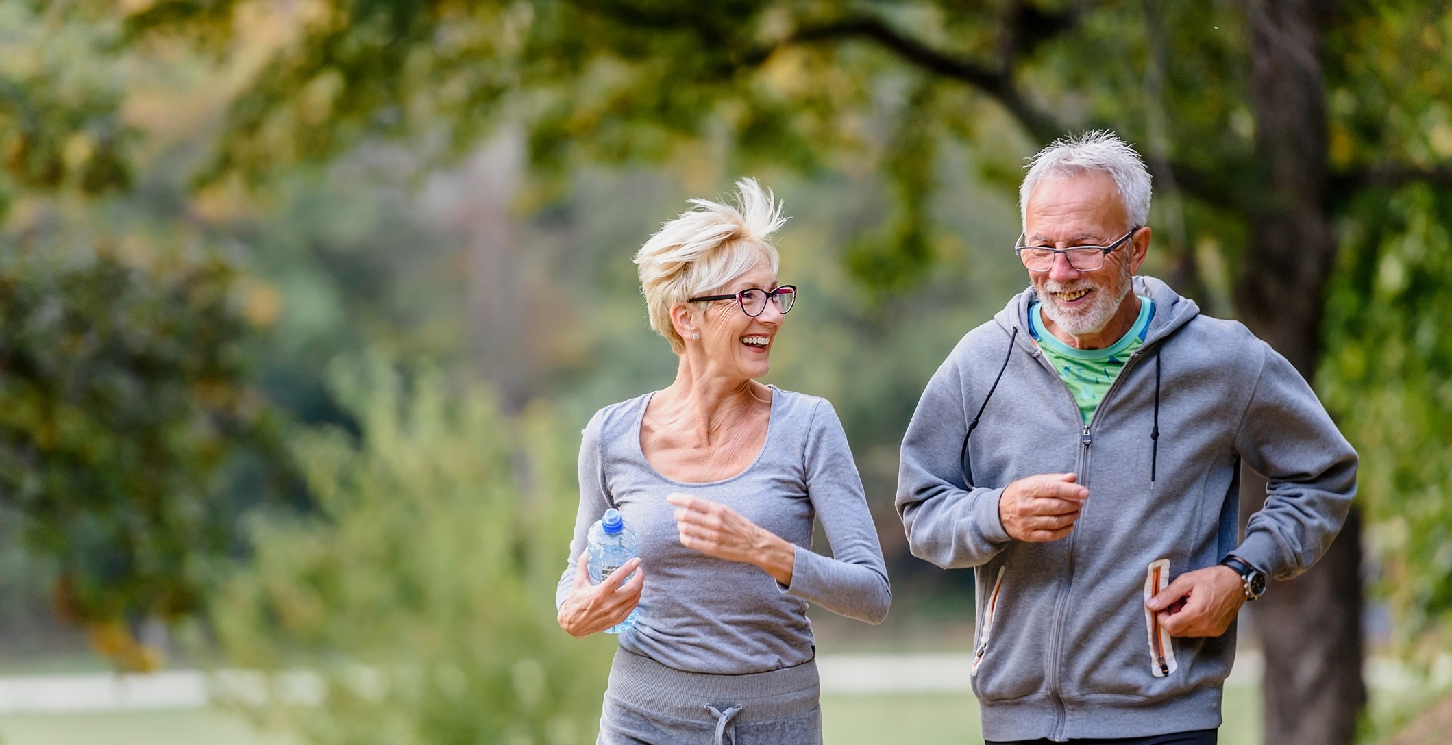 Un homme âgé et une femme âgée font une course à pieds dans un parc