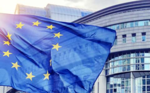 Drapeau de l'Europe flottant devant un bâtiment. 