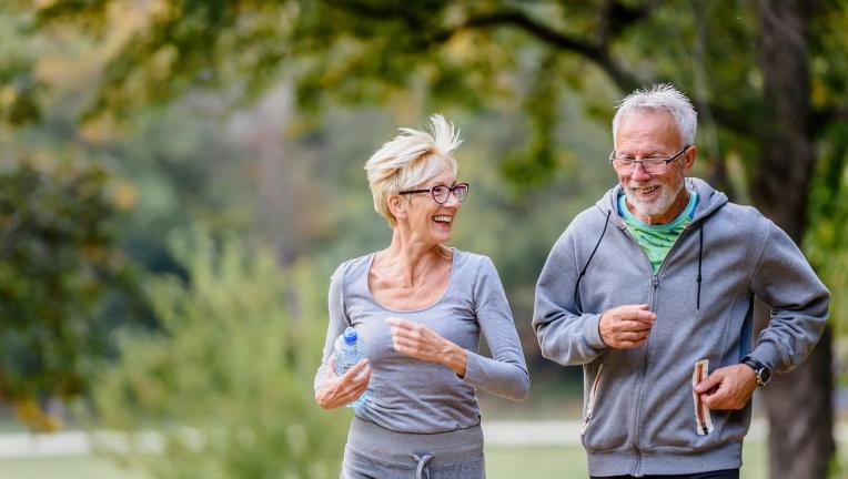 Un homme âgé et une femme âgée font une course à pieds dans un parc