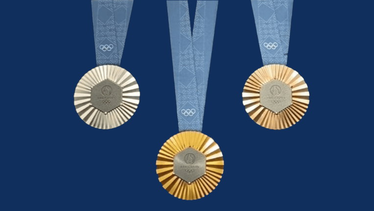 Photo avec 3 médailles JOP (or, argent et bronze) sur fond bleu