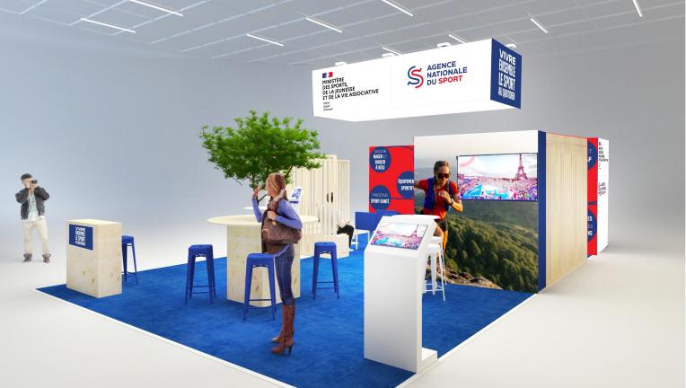 Image du stand au salon des Maires 2025 présentant un écran, des chaises, des tables, l'habillage avec les logos du ministère des Sports et de l'ANS.