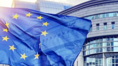 Drapeau de l'Europe flottant devant un bâtiment. 