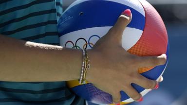 Joueuse de volley-beach tenant un ballon 