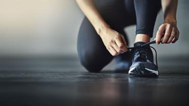 Femme sportive en train de lacer ses chaussures de sport