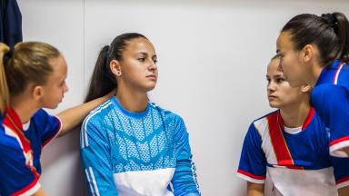 Image de quatre jeunes sportives en train de discuter dans les vestiaires
