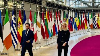 Photo de Marie Marsacq au conseil européen à Bruxelles avec des drapeaux