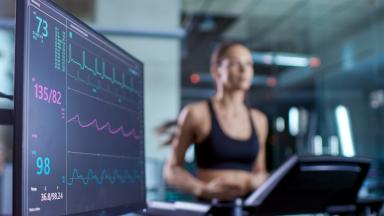 Ecran d'ordinateur avec fréquences cardiaques et une sportive en train de courir