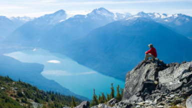 Photo d'une personne assise et admirant la montagne