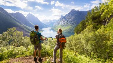 Image avec un homme et une femme en escalade contemplant la montagne en été