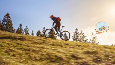 Bannière Open Badges avec un cycliste dans la nature et le logo du badge