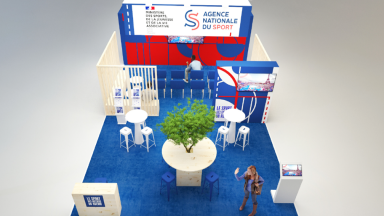 Image du stand au salon des Maires 2025 présentant un écran, des chaises, des tables, l'habillage avec les logos du ministère des Sports et de l'ANS.